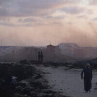 Displaced Palestinians walk through a makeshift tent camp at the Gaza City port on May 22, 2025. (AP Photo/Jehad Alshrafi)