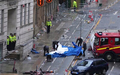 Police and emergency personnel deal with an incident after a car collided with pedestrians near the Liver Building during the Premier League winners parade in Liverpool, England, May 26, 2025.(Jon Super/AP)