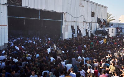 Palestinians storm a UN World Food Program warehouse and carry bags of flour in Zawaida, Deir Al-Balah, Central Gaza Strip, on May 28, 2025. (Abdel Kareem Hana/AP)