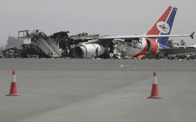 A man walks in front of a damaged Yemeni plane at Sanaa International Airport in Sanaa, Yemen, Thursday, May 29, 2025, a day after Israeli airstrikes on the Houthi-controlled airport. (AP Photo/Osamah Abdulrahman)