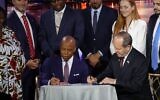 New York City Mayor Eric Adams, left, and Economy Minister Nir Barkat, right, ink an agreement to build business ties between New York and Israel, in New York City, May 19, 2025. (Luke Tress/ Times of Israel)