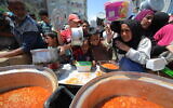 Displaced Palestinians line up to receive a meal in the northern Gaza Strip, on May 5, 2025. (Ali Hassan/Flash90)