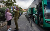 An Israeli reservist kissing his wife and child goodbye as he leaves for reserve duty in Jerusalem, May 5, 2025. (Chaim Goldberg/Flash90)
