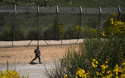 An Israeli soldier on the border fence with Syria, in the northern Israeli town of Majdal Shams, on May 9, 2025. (Michael Giladi/FLash90)