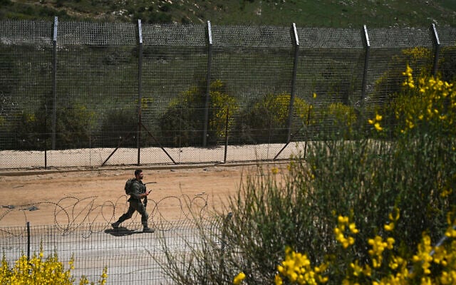 An Israeli soldier on the border fence with Syria, in the northern Israeli town of Majdal Shams, on May 9, 2025. (Michael Giladi/FLash90) An Israeli soldier on the border fence with Syria, in the northern Israeli town of Majdal Shams, on May 9, 2025. (Michael Giladi/FLash90)