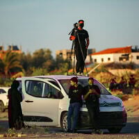 Members of the press wait for a Red Cross convoy after Hamas's release of American-Israeli hostage Edan Alexander, on Salah al-Din Street, east of Deir al-Balah, in the central Gaza Strip, May 12, 2025. (Ali Hassan/Flash90)