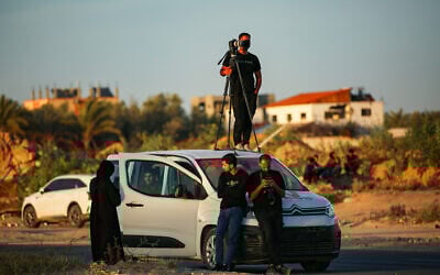 Members of the press wait for a Red Cross convoy after Hamas's release of American-Israeli hostage Edan Alexander, on Salah al-Din Street, east of Deir al-Balah, in the central Gaza Strip, May 12, 2025. (Ali Hassan/Flash90)