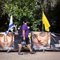 People walk by posters of hostage Edan Alexander on May 12, 2025. (Miriam Alster/Flash90)