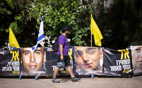 People walk by posters of hostage Edan Alexander on May 12, 2025. (Miriam Alster/Flash90)
