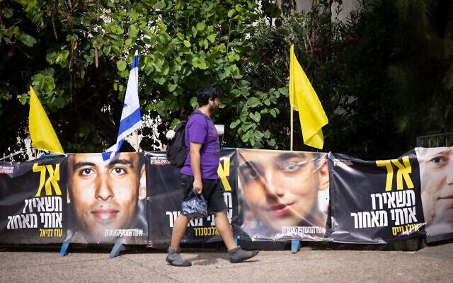 People walk by posters of hostage Edan Alexander on May 12, 2025. (Miriam Alster/Flash90)