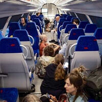 People take cover as a siren warns of an incoming missile fired from Yemen, on a train in Jerusalem, May 13, 2025. (Dor Pazuelo/Flash90)