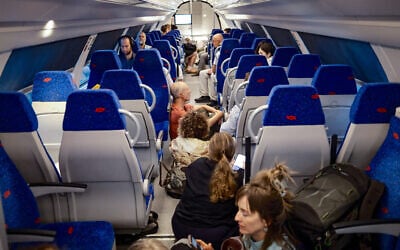 People take cover as a siren warns of an incoming missile fired from Yemen, on a train in Jerusalem, May 13, 2025. (Dor Pazuelo/Flash90)
