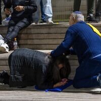 People take cover as siren warns of an incoming missile fired from Yemen, in Jerusalem, May 15, 2025. (Oren Ben Hakoon/Flash90)