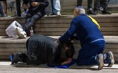 People take cover as siren warns of an incoming missile fired from Yemen, in Jerusalem, May 15, 2025. (Oren Ben Hakoon/Flash90)
