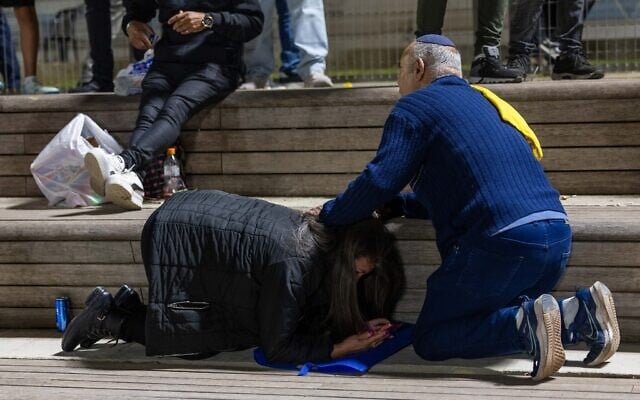 People take cover as siren warns of an incoming missile fired from Yemen, in Jerusalem, May 15, 2025. (Oren Ben Hakoon/Flash90)