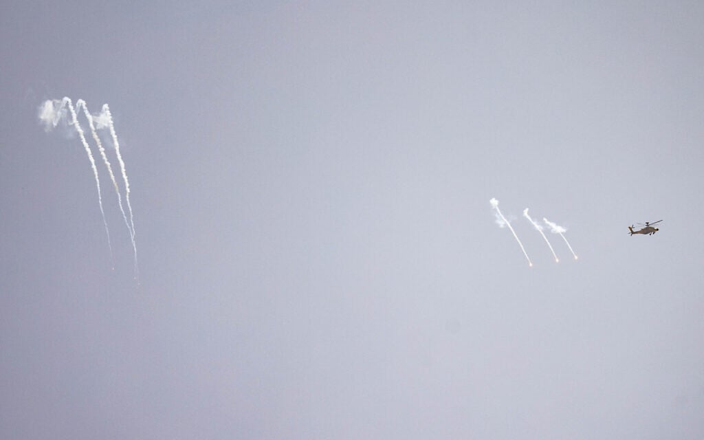 An Israeli combat helicopter fires flares as seen from a position on the Israeli border with the Gaza Strip, May 18, 2025 (Chaim Goldberg/Flash90)