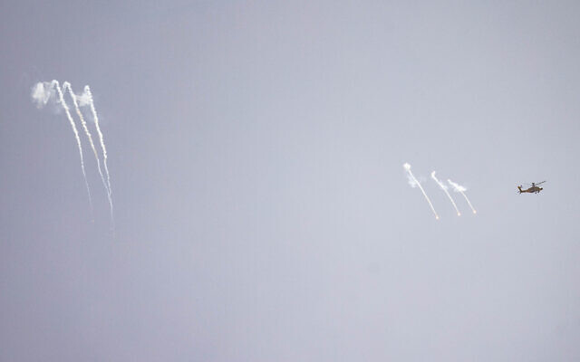 An Israeli combat helicopter fires flares as seen from a position on the Israeli border with the Gaza Strip, May 18, 2025 (Chaim Goldberg/Flash90)