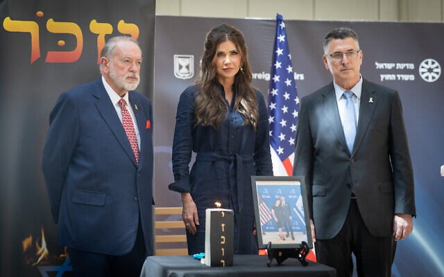 US Secretary of Homeland Security Kristi Noem (C) alongside Foreign Minister Gideon Sa’ar (R) and US Ambassador to Israel Mike Huckabee  at the Foreign Ministry in Jerusalem, for a memorial for Yaron Lischinsky and Sarah Lynn Milgrim, who were shot and killed near the Jewish Museum in Washington, May 26, 2025 (Chaim Goldberg/Flash90)