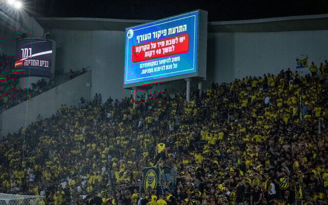 A Home Front Command warning of incoming missile fire appears on a jumbotron during the final of the Israel State Cup between Hapoel Beersheba and Beitar Jerusalem at the Bloomfield Stadium in Tel Aviv, May 29, 2025. (Oren Ben Hakoon/Flash90) A Home Front Command warning of incoming missile fire appears on a jumbotron during the final of the Israel State Cup between Hapoel Beersheba and Beitar Jerusalem at the Bloomfield Stadium in Tel Aviv, May 29, 2025. (Oren Ben Hakoon/Flash90)