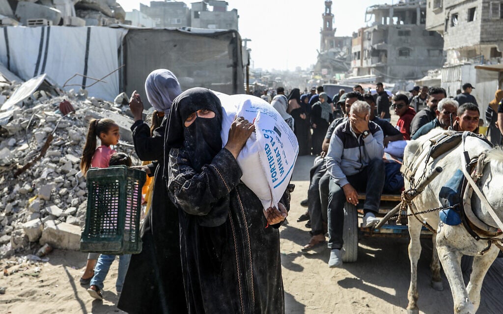 Palestinians carry bags of flour stolen from humanitarian aid trucks entering the Gaza Strip, in Khan Younis, southern Gaza Strip, May 31, 2025. (Abed Rahim Khatib/Flash90) Palestinians carry bags of flour stolen from humanitarian aid trucks entering the Gaza Strip, in Khan Younis, southern Gaza Strip, May 31, 2025. (Abed Rahim Khatib/Flash90)
