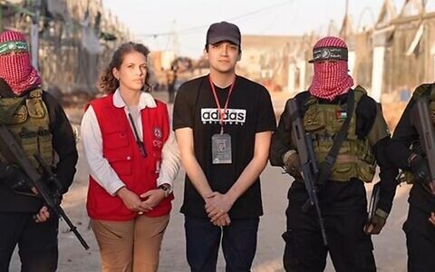 Freed hostage Edan Alexander with a representative of the Red Cross, flanked by Hamas gunmen in the Gaza Strip on May 12, 2025. (via Al Jazeera)