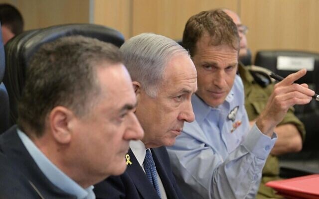 This handout photo shows Prime Minister Benjamin Netanyahu (C), Defense Minister Israel Katz (L) and  Brig. Gen. Omer Tischler, the IAF’s chief of staff, observing strikes on Houthi targets in the Yemeni capital of Sanaa, at the Kirya military headquarters in Tel Aviv on May 6, 2025. (Amos Ben Gershom/GPO)
