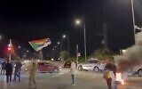 A protester stands atop a car waving the Druze flag during a demonstration in northern Israel calling for the government to help the Druze community in Syria amid sectarian violence, May 1, 2025. (Screenshot, X: Used in accordance with Clause 27a of the Copyright Law)
