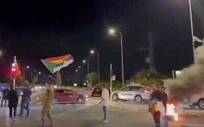 A protester stands atop a car waving the Druze flag during a demonstration in northern Israel calling for the government to help the Druze community in Syria amid sectarian violence, May 1, 2025. (Screenshot, X: Used in accordance with Clause 27a of the Copyright Law)