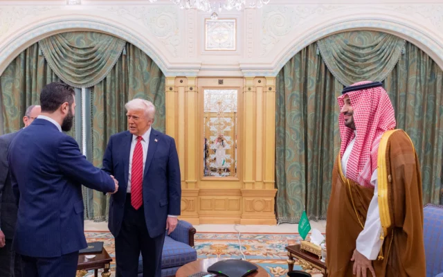 US President Donald Trump shakes hands with Syrian President Ahmad al-Sharaa as Saudi Crown Prince mohammad Bin Salman looks on, in Riyadh, May 14, 2025. (Saudi Royal Palace)