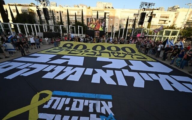 A gigantic flag of the “Brothers in Arms” reservist protest group is spread out at Habima Square in Tel Aviv, reading, “80,000 draft evaders on the backs of the reservists.” (Alon Banki/Pro-Democracy Protest Movement) A gigantic flag of the “Brothers in Arms” reservist protest group is spread out at Habima Square in Tel Aviv, reading, “80,000 draft evaders on the backs of the reservists.” (Alon Banki/Pro-Democracy Protest Movement)