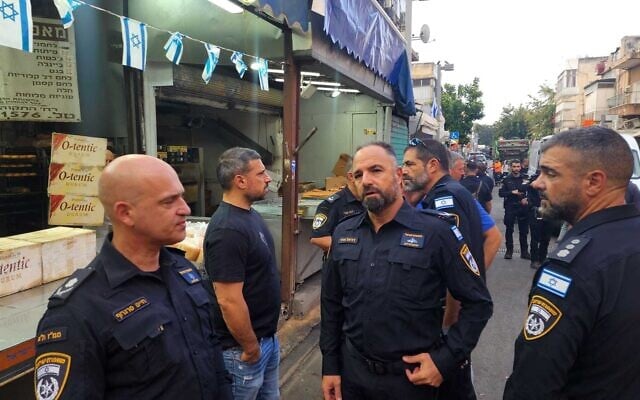 Tel Aviv police chief Haim Sargrof, left, and other senior cops at the scene of a suspected deadly robbery in Tel Aviv on May 27, 2025. (Police Spokesperson)