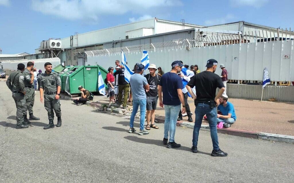 Protesters are cleared away by police after attempting to block trucks carrying aid to Gaza, outside the Ashdod port, on May 27, 2025. (Police spokesperson)