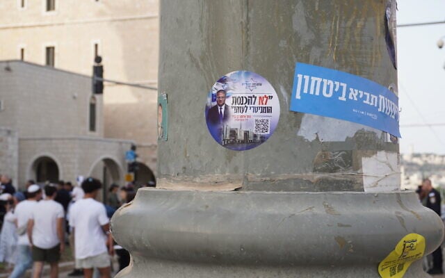 Stickers that read "No to the entry of humanitarian aid into Gaza" and "sovereignty will bring security" plastered on a pole in Jerusalem on May 26, 2025. (Charlie Summers/Times of Israel)