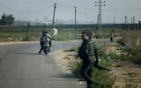 Hamas terrorists move towards the Erez crossing between Israel and the northern Gaza Strip, during the terror group's onslaught on October 7, 2023.  (Mohammed ABED / AFP)