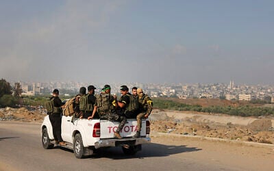 Hamas terrorists move toward the Erez crossing between Israel and the northern Gaza Strip, during the terror group's onslaught in southern Israel on October 7, 2023. (Mohammed ABED / AFP) Hamas terrorists move toward the Erez crossing between Israel and the northern Gaza Strip, during the terror group's onslaught in southern Israel on October 7, 2023. (Mohammed ABED / AFP)