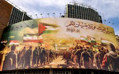 A giant billboard depicting Muslim peoples walking with flags toward the Dome of the Rock shrine in Jerusalem is erected in Valiasr Square in the center of Tehran, October 25, 2023. (Atta Kenare / AFP)