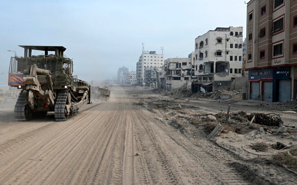 An IDF bulldozer drives along a street during a military operation in the northern Gaza Strip amid continuing battles between Israel and Hamas, November 22, 2023. (Ahikam SERI / AFP)