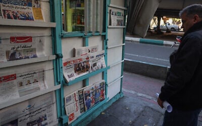 Illustrative: An Iranian man looks at newspapers displayed outside a kiosk in Tehran on November 6, 2024. (ATTA KENARE / AFP)