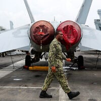 Illustrative: A US Navy officer walks past fighter jets parked on the flight deck of the Nimitz-class aircraft carrier USS Abraham during a media tour in Port Klang, on the outskirts of Kuala Lumpur, on November 26, 2024. (FAZRY ISMAIL / POOL / AFP)