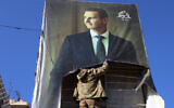 An anti-government fighter tears down a portrait of Syria's President Bashar al-Assad in Aleppo, after jihadists and their allies entered the northern Syrian city, on November 30, 2024. (Mohammed AL-RIFAI / AFP)