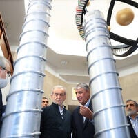 A handout picture provided by the Iranian presidency shows President Masoud Pezeshkian, second left, and the Atomic Energy Organization of Iran chief Mohammad Eslami, second right, during the 'National Day of Nuclear Technology,' in Tehran, on April 9, 2025. (Iranian Presidency / AFP)