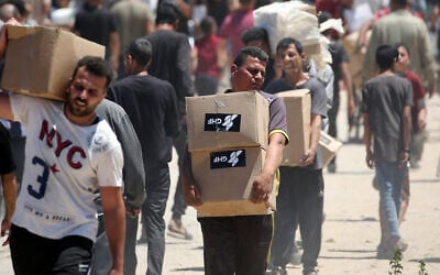 People carry boxes of relief supplies distributed by the US- and Israel-backed Gaza Humanitarian Foundation at an aid distribution center in the central Gaza Strip on May 29, 2025. (Eyad BABA / AFP) People carry boxes of relief supplies distributed by the US- and Israel-backed Gaza Humanitarian Foundation at an aid distribution center in the central Gaza Strip on May 29, 2025. (Eyad BABA / AFP)