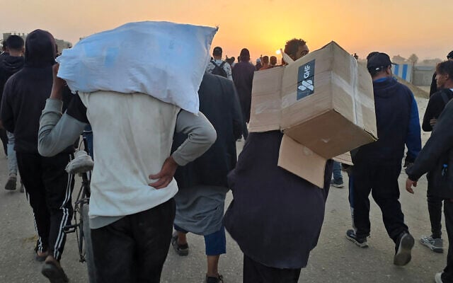 A youth carries an empty box of relief supplies from the Gaza Humanitarian Foundation, as displaced Palestinians walk near a food distribution center in Rafah, in the southern Gaza Strip on June 1, 2025. (AFP) A youth carries an empty box of relief supplies from the Gaza Humanitarian Foundation, as displaced Palestinians walk near a food distribution center in Rafah, in the southern Gaza Strip on June 1, 2025. (AFP)