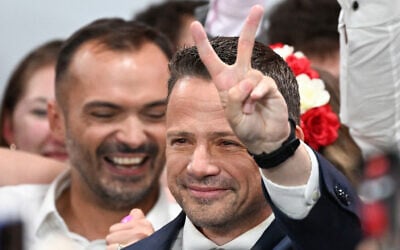 Rafal Trzaskowski, Warsaw's Mayor and member of ruling centrist Civic Coalition party, flashes a V for victory sign as he greets supporters as exit polls were announced on tv during their election night event at the the National Museum of Ethnography in Warsaw, Poland, during the second round of the presidential elections on June 1, 2025. (Sergei GAPON / AFP)