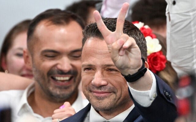 Rafal Trzaskowski, Warsaw's Mayor and member of ruling centrist Civic Coalition party, flashes a V for victory sign as he greets supporters as exit polls were announced on tv during their election night event at the the National Museum of Ethnography in Warsaw, Poland, during the second round of the presidential elections on June 1, 2025. (Sergei GAPON / AFP) Rafal Trzaskowski, Warsaw's Mayor and member of ruling centrist Civic Coalition party, flashes a V for victory sign as he greets supporters as exit polls were announced on tv during their election night event at the the National Museum of Ethnography in Warsaw, Poland, during the second round of the presidential elections on June 1, 2025. (Sergei GAPON / AFP)