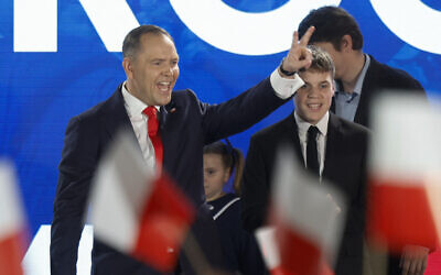 Karol Nawrocki, candidate for the 2025 Polish presidential election supported by Poland's right-wing Law and Justice (PiS) party, flashes the victory sign in front of supporters as exit polls were announced on tv during their election night event at the Mala Warszawa Theatre in Warsaw, Poland, during the second round of the presidential elections on June 1, 2025. (Photo by Wojtek RADWANSKI / AFP)