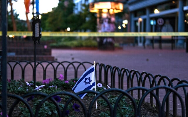 An Israeli flag stands in a bed of flowers as caution tape blocks off a deserted Pearl Street on the scene of an attack on demonstrators calling for the release of Israeli hostages held in Gaza, in Boulder, Colorado, on June 1, 2025.  (Photo by Eli Imadali / AFP)
