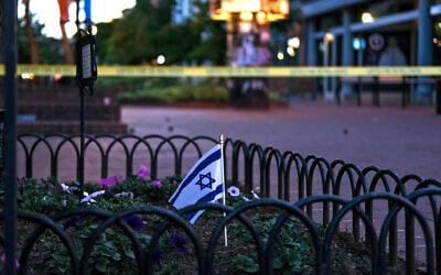 An Israeli flag stands in a bed of flowers as caution tape blocks off the scene of an attack on demonstrators calling for the release of Israeli hostages held in Gaza, in Boulder, Colorado, on June 1, 2025. (Eli Imadali / AFP)