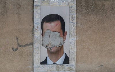 A defaced portrait of Syria's ousted president Bashar al-Assad hangs on a wall in the capital Damascus on June 2, 2025. (LOUAI BESHARA / AFP)