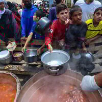 Palestinians wait for food at a distribution point in Nuseirat, central Gaza Strip, June 2, 2025. (Eyad BABA / AFP)